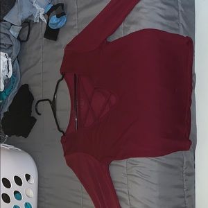 A maroon shirt that has a cut down in the chest.